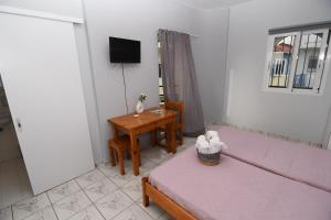 a bedroom with a bed and a table and a television at Kanali Apartments in Kanali