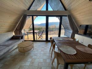 a living room with a table and a large window at Biestroska - apartamenty widokowe in Wetlina +47 photos