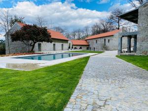 a stone house with a swimming pool in a yard at Casa da Fonte de Cima in Celorico de Basto