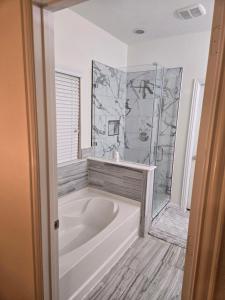 a white tub in a bathroom with a shower at Elegant family home in Cypress +45 photos