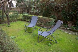 due sedie sedute nell'erba in un cortile di Lounge House Vatican - San Pietro a Roma
