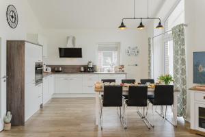 - une cuisine avec une table à manger et des chaises dans l'établissement Ferienhaus Hofkiek - Bauernhof Hopp Vadersdorf, à Fehmarn