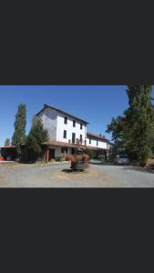 a large white house sitting on top of a street at Cascina Valgrande, Monferrato in Carpeneto