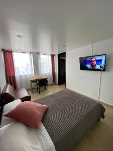 a bedroom with a bed and a tv on the wall at HOTEL Destino Nómada Calle 11 n 1-38 in Bogotá