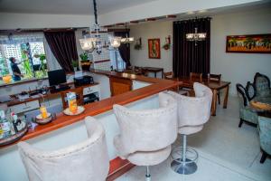 a living room with a bar and some chairs at B&B HOTEL in Moshi