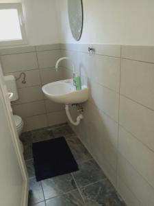 a bathroom with a sink and a mirror and a toilet at Log Cabins Jovicic in Bosanska Dubica +25 photos