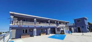 a blue house with a balcony on top of it at Hotel Casa Victoria in Puerto Peñasco