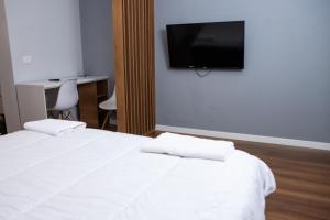 a bedroom with a bed and a tv on the wall at Be Solei Studio Apartments Sol 1 in Tirana