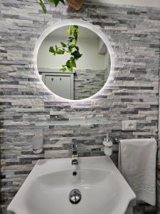 a bathroom with a white sink and a mirror at La suite (Sole) in Lido di Pomposa +7 photos