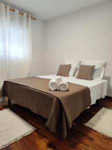 a bedroom with a bed with two towels on it at Melo's Home in Santo Amaro