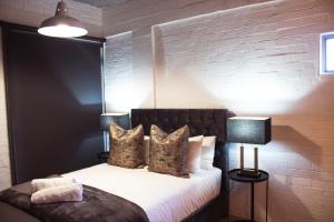 a bedroom with a bed with a brick wall at Swift Studios No4 in Cape Town