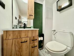 a bathroom with a white toilet and a green wall at Monte Poddasze I Ciasna ale wanna I 5 minut plaża in Sopot +14 photos