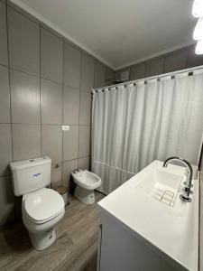 a white bathroom with a toilet and a sink at Decorama Vista in Dolores +18 photos