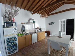 a kitchen with a white table and a white refrigerator at Casa do Cais in Monte +51 photos