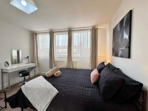 a bedroom with a large bed and a desk at Ocean Apartment, Spacious 5 bedroom holiday home in Whitley Bay
