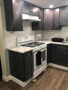 a kitchen with black cabinets and a stove top oven at Charming Hudson Valley 3-Bedroom Family Getaway in Tomkins Cove