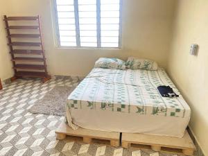 een slaapkamer met een bed in een kamer met een raam bij Litos place in Cotonou