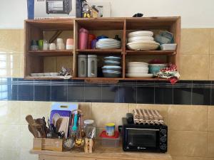 een aanrecht met een magnetron en servies bij Litos place in Cotonou