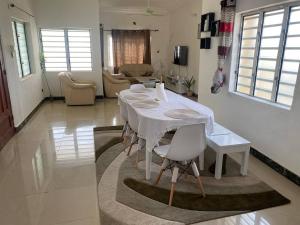 een witte tafel en stoelen in de woonkamer bij Litos place in Cotonou