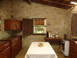una cocina con una mesa en el medio. en Jungle House, en São Miguel do Gostoso 17 fotos más