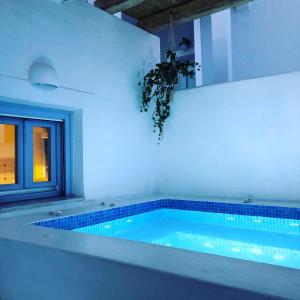 a swimming pool with blue lights in a room at Elkaza Villas in Fira