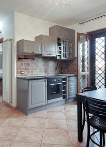 Una cocina con electrodomésticos de acero inoxidable y una mesa. en Le Terrazze Ciampino, en Ciampino