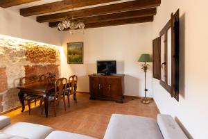 a living room with a table and a tv at La Casa de la Botica - Casa Rural El Romeral in Romeral