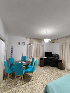 a living room with a table and blue chairs at Apartmani Mislav in Slatine