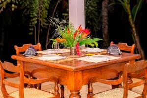 a wooden table with chairs around it with flowers on it at Halketha in Matugama