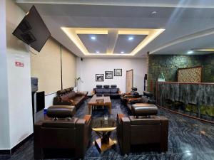 a waiting room with leather couches and a tv at GrandTaj in Murree