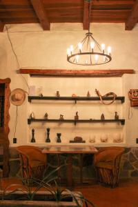 a chandelier hanging over a table with vases on shelves at Hotel y restaurante Cuenca Antigua in Mazamitla +4 photos
