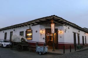 a white building with a car parked in front of it at Hotel y restaurante Cuenca Antigua in Mazamitla