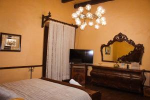 a bedroom with a bed and a mirror and a dresser at Hotel y restaurante Cuenca Antigua in Mazamitla