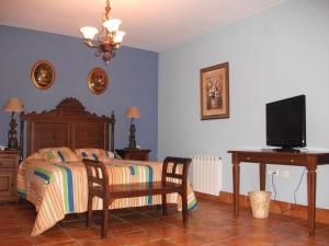 Schlafzimmer mit einem Bett, einem Schreibtisch und einem TV in der Unterkunft Hotel Los Rebites in Huétor Vega
