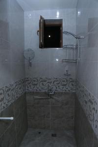 Un baño con ducha con puerta de cristal. en Hostel Room, en Tashkent