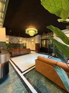 a lobby with a couch and a chandelier at Getaway Liège in Liège