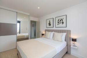 a white bedroom with a large bed and a mirror at Villa 23 A heated pool in Trogir +42 photos