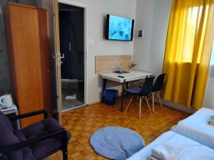 a small room with a table and a bed and a table and chairs at Hotelik Krakowiak in Jarosław