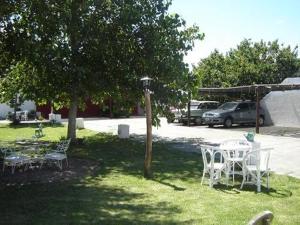 a table and chairs in a yard with a car at La Vecindad del Sol Depto D in Miramar