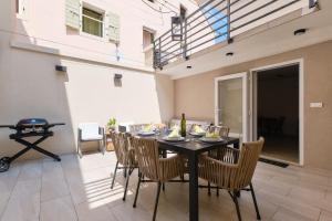 a dining room with a black table and chairs at Lošinj Chic Retreat in Mali Lošinj