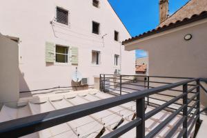 a balcony with stairs leading to a white building at Lošinj Chic Retreat in Mali Lošinj