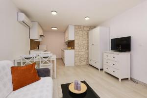 a living room with a white couch and a kitchen at Lošinj Chic Retreat in Mali Lošinj
