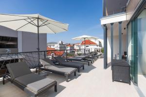 a row of chairs and umbrellas on a balcony at Villa 23 A heated pool in Trogir