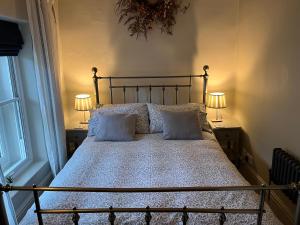 Granby Cottage, Peak District National Park في تيديسويل: غرفة نوم بها سرير مع مصباحين