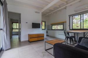 a living room with a couch and a table at PRANAMAR, apart del bosque in Santa Teresita