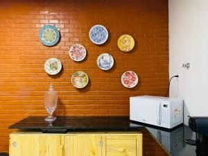 a wall with plates on a brick wall at Casa Miriti Hostel - a 200m da Basílica de Nazaré in Belém