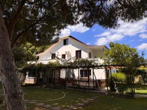 a white house with a fence and a tree at Keyfe Kadir Garden Butik Otel in Orhangazi