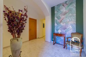 a hallway with a vase with flowers and a table at Al Convento Bed & Breakfast Vasto Marina in Vasto