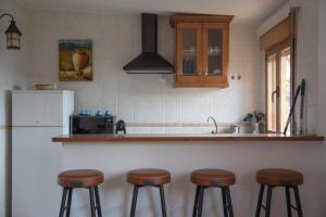 cocina con 3 taburetes y nevera en 'El Mirador de Sotillo', un Oasis de Confort con Piscina y Jacuzzis, en Sotillo de la Adrada