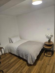 a white bedroom with a bed and a table at The Dell - Rushden Lakes in Rushden